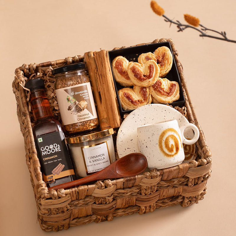 The Knot Company Cinnamon Collection Gift Set of 7 Assorted Items | Cinnamon Candle, Sticks, Syrup, Cookies, Hazelnut Cinnamon Coffee, Cup & Saucer and Wooden Spoon